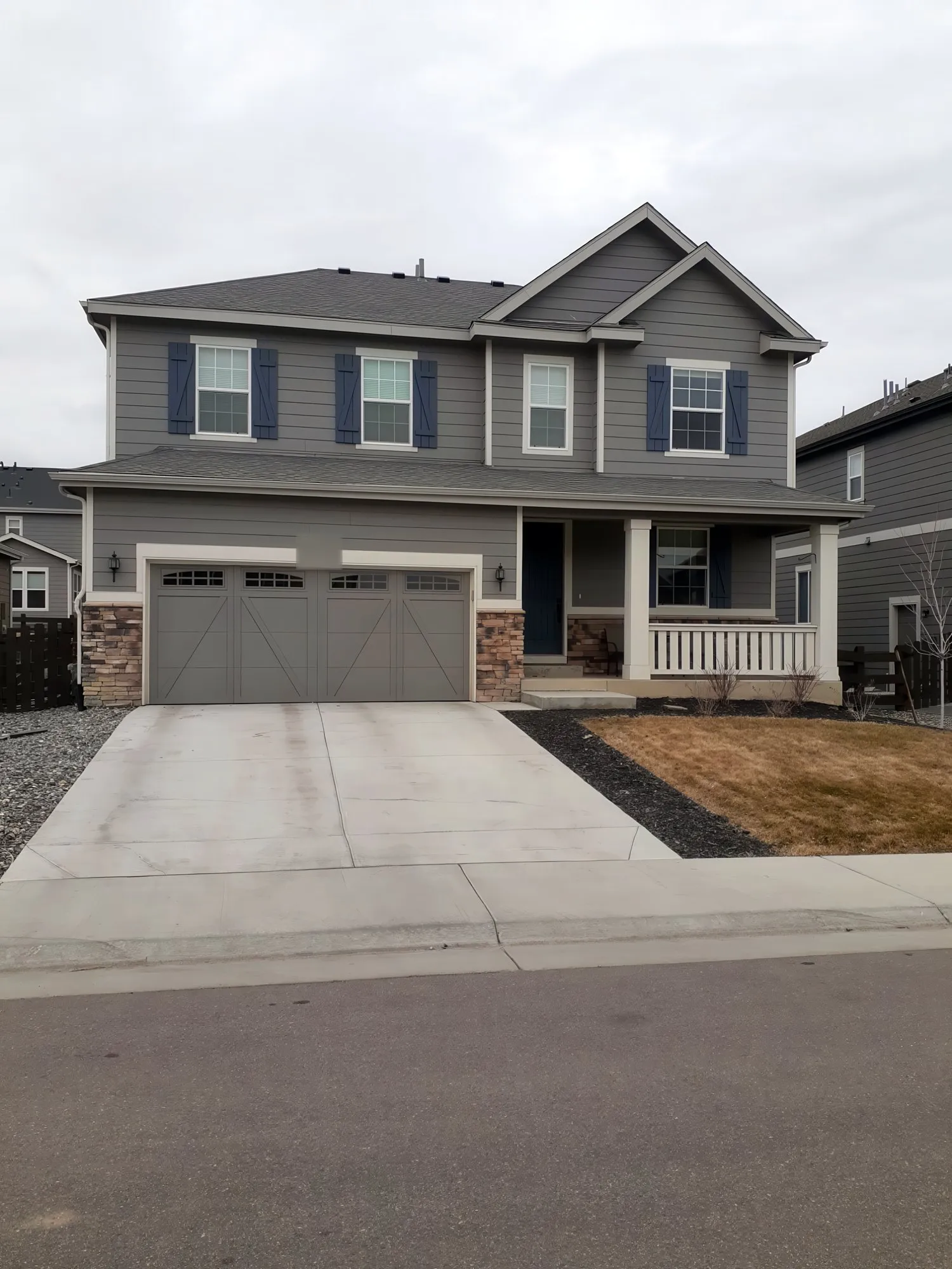 Gray two-story house with navy shutters and a white porch