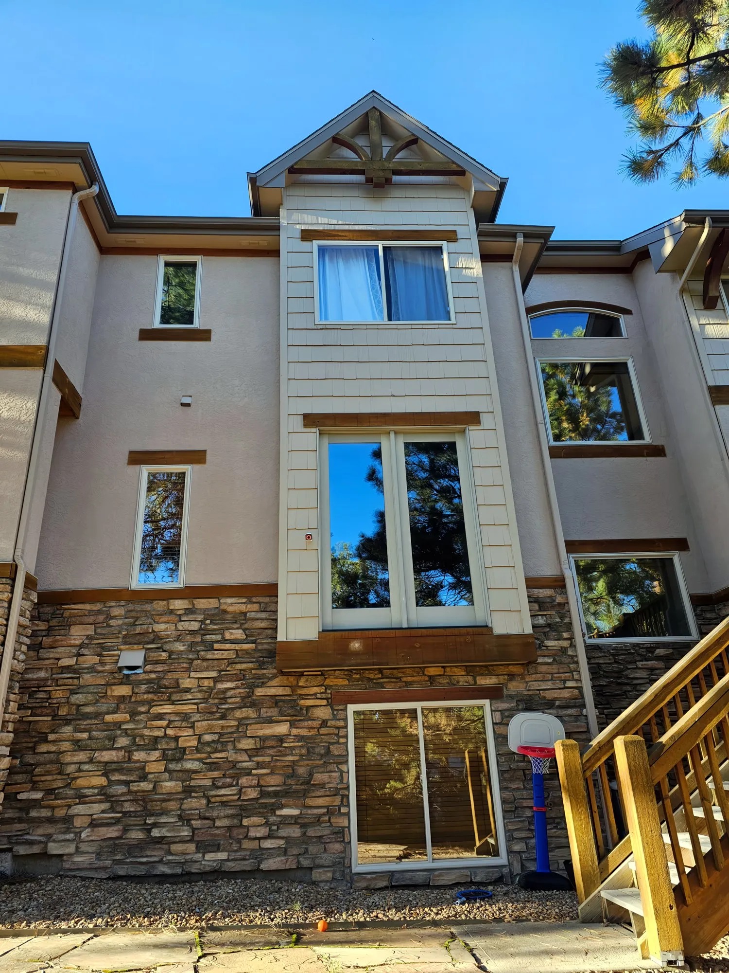 Rear of a three-story home with stucco, siding and wood trim