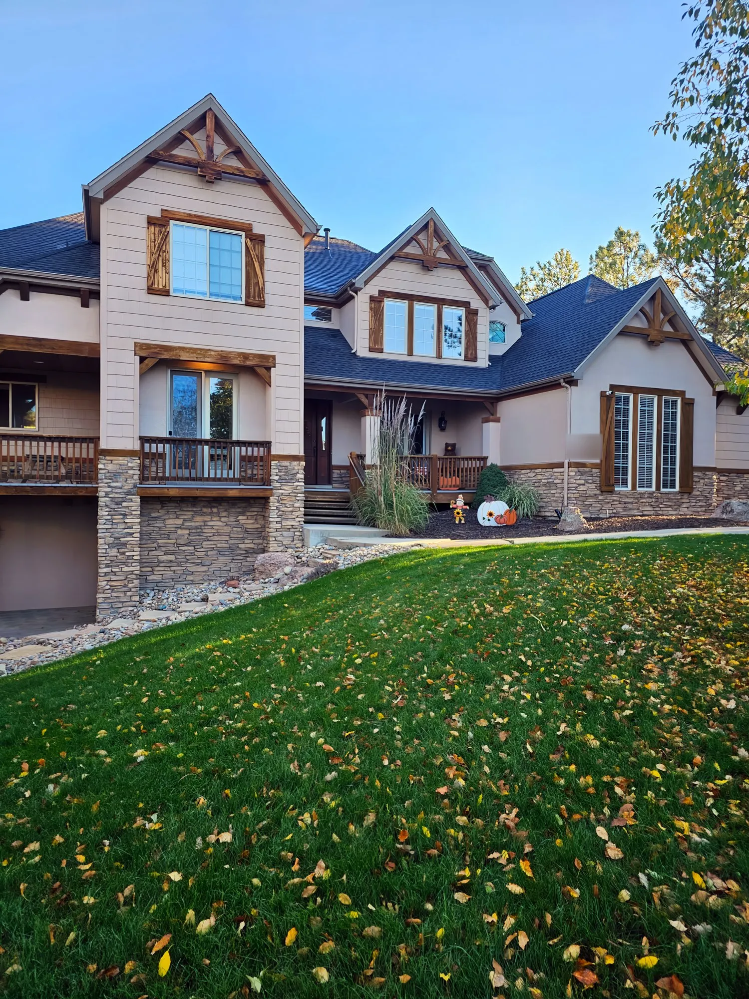 Large two-story craftsman-style home with stone accents and a lawn
